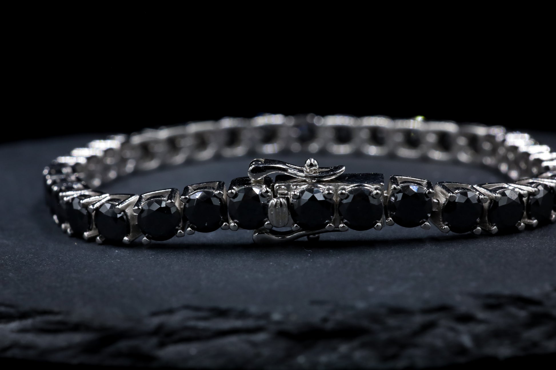 Silver bracelet with black moissanite gem stones on a dark background