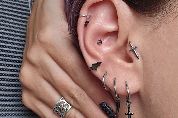 Lux Punk Threadless Studs Black bat on Tabitha's Ear, 4th lobe, black moon bottom helix, silver dagger tragus, black spike dangle, black dagger dangle, titanium hinge hoops